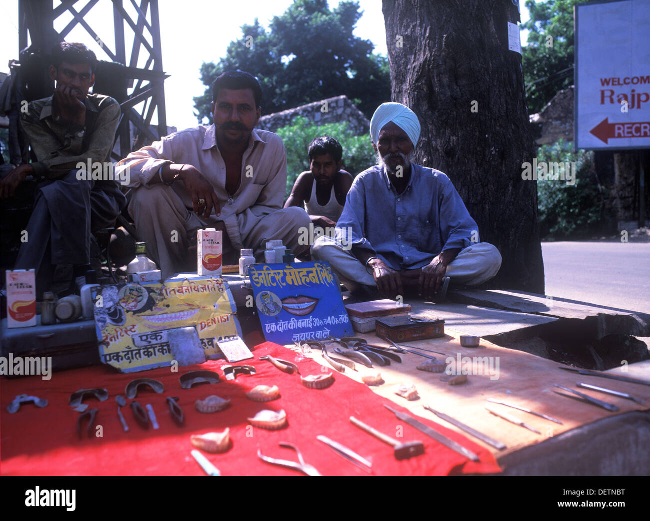 Street dentist surrounded by his tools of trade sitting in the street in Rajasthan, India. Stock Photo