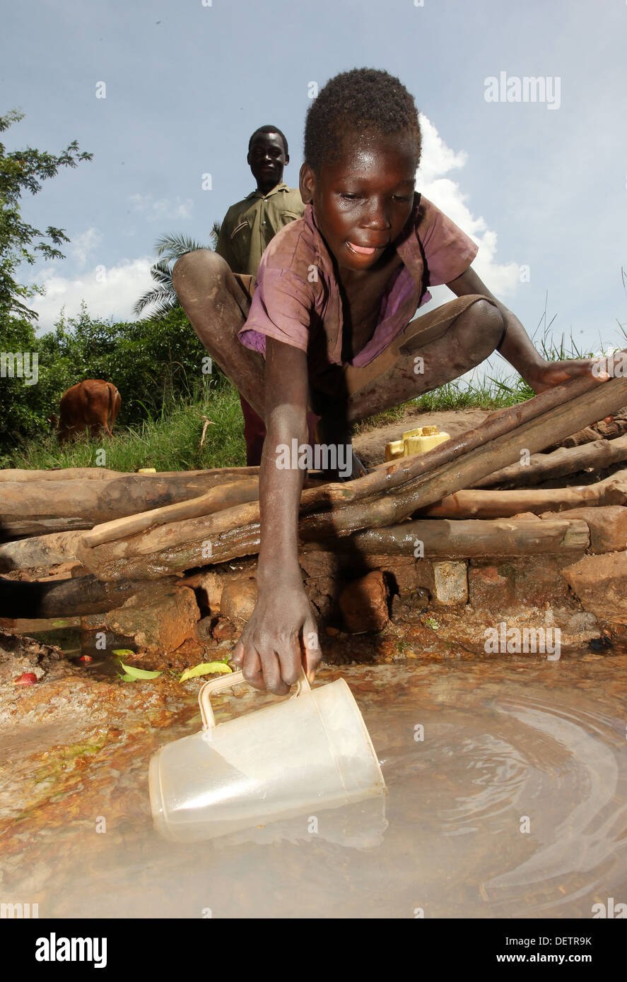 Village children collect water from a dirty water source in the Lira district of northern Uganda Stock Photo