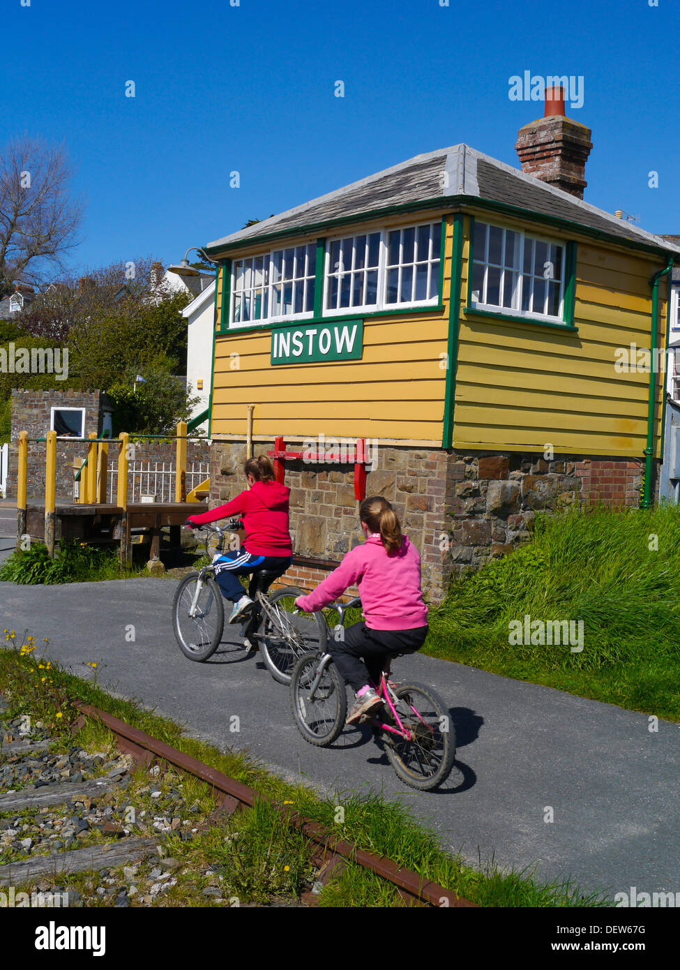 Young cyclists passing old signal box on Tarka Trail at Instow Devon England Stock Photo