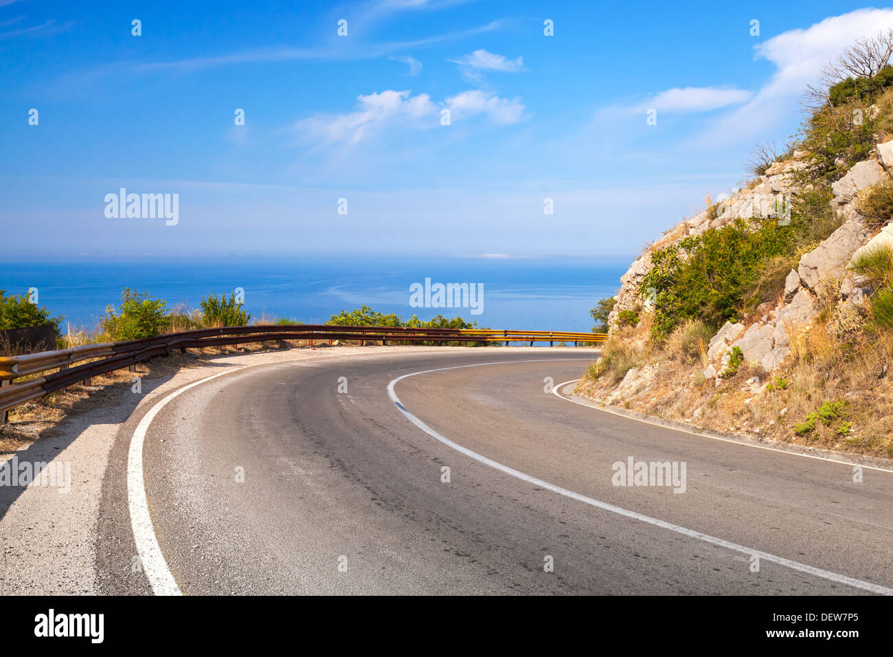 Turn of mountain highway with blue sky and sea on a background Stock Photo