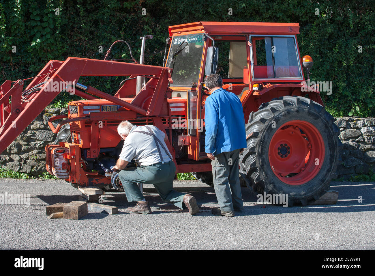 farmer farm labourer laborer repairing tractor Stock Photo Alamy