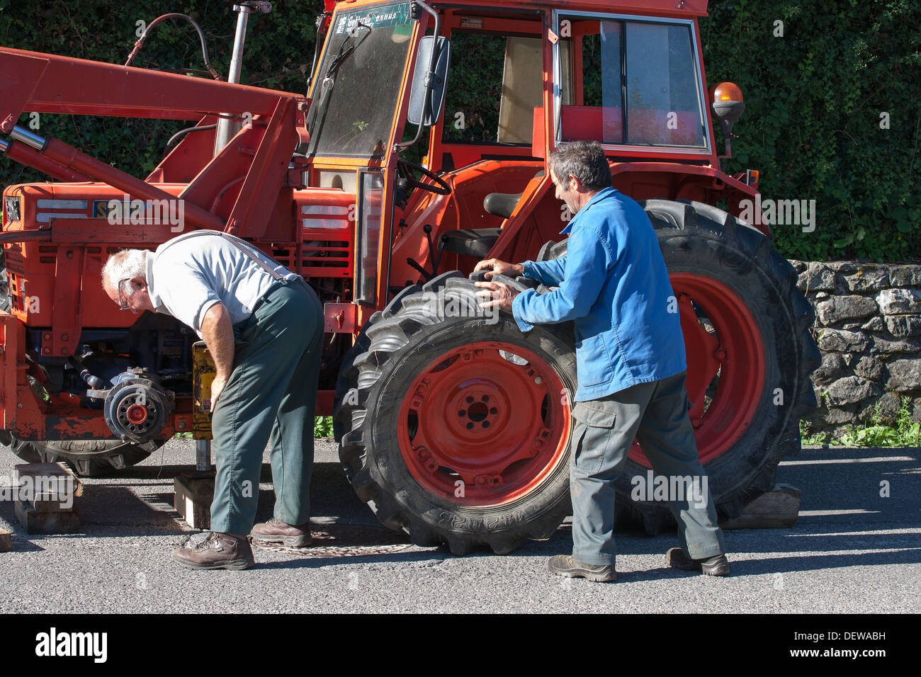 farmer farm labourer laborer repairing tractor Stock Photo Alamy