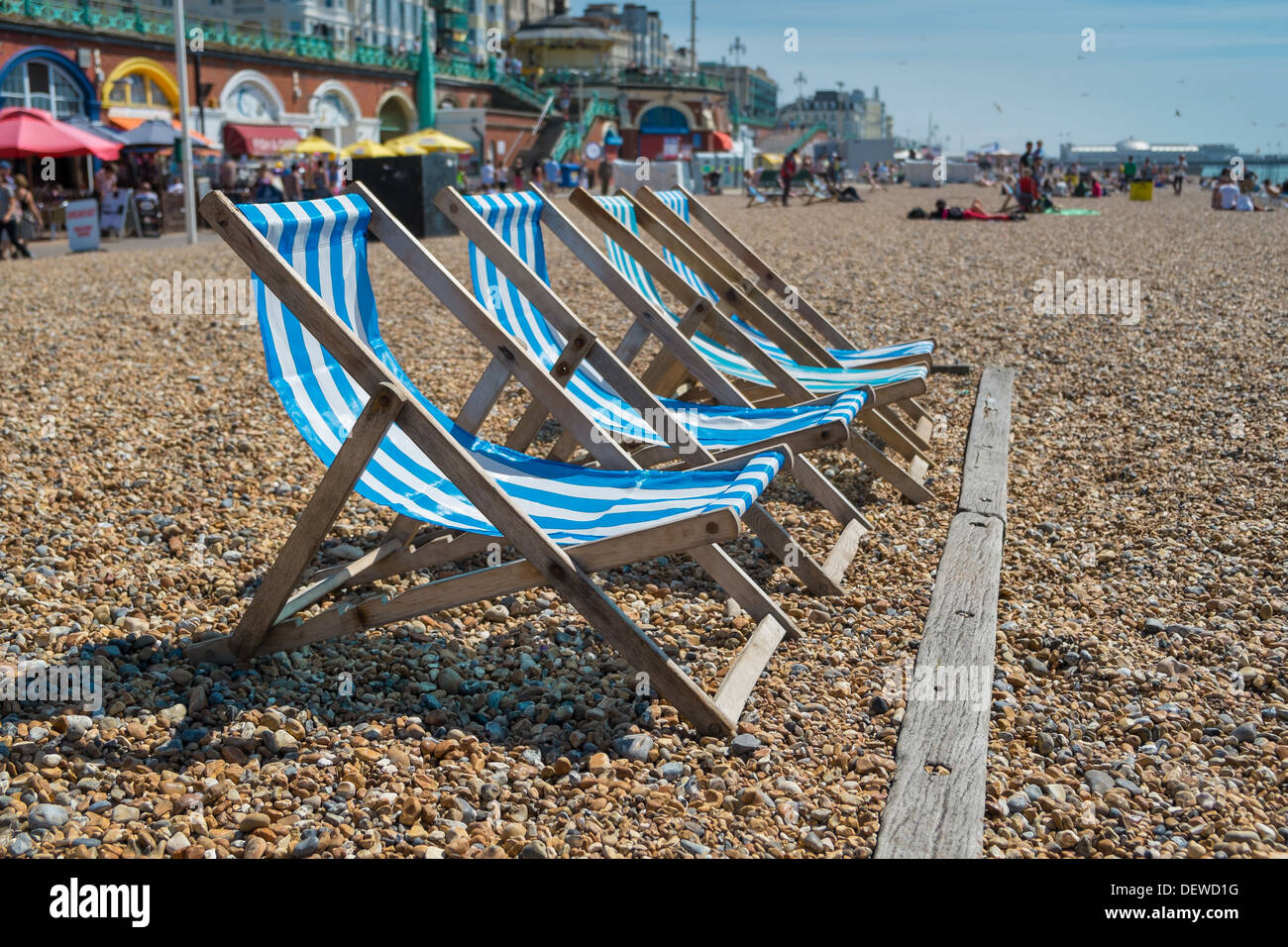 4 blue deck chairs on Brightons pebble beach Stock Photo