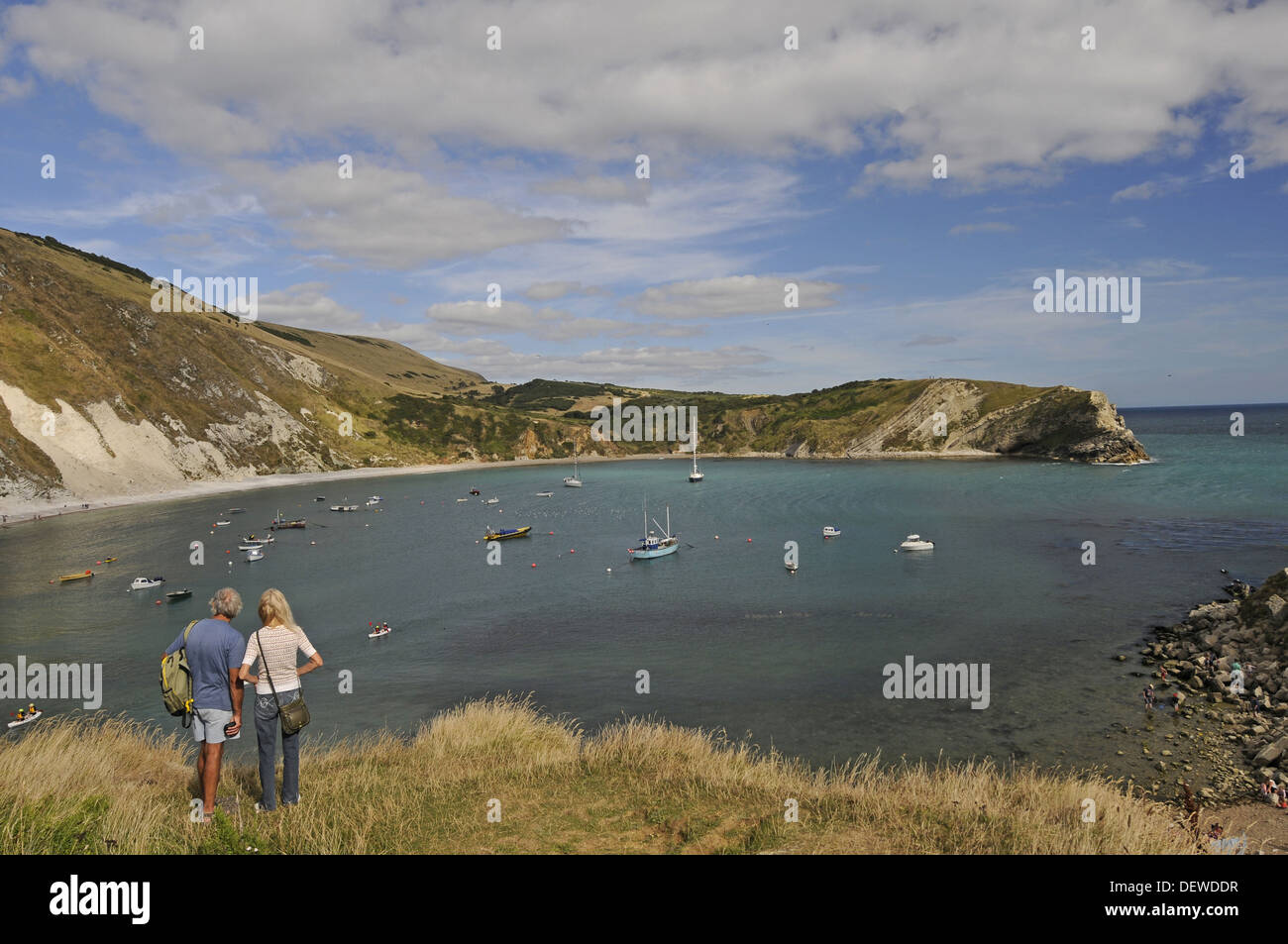 Couple looking out over Lulworth Cove on the Jurassic Coast Isle of Purbeck Dorset England Stock Photo