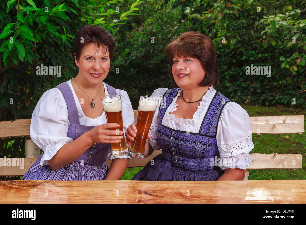 Two women in dirndls drinking beer Stock Photo