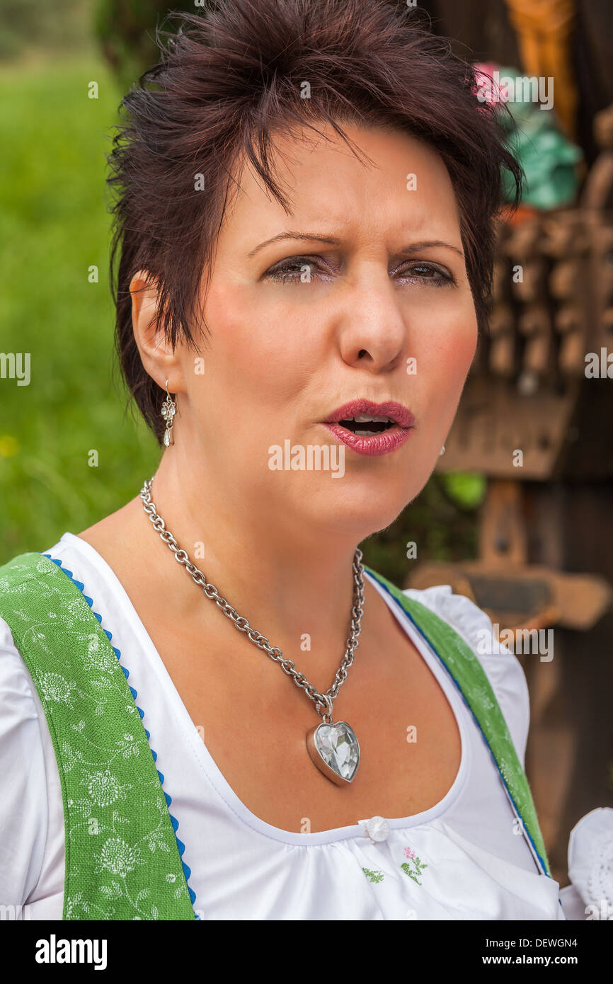 Attractive German lady in a dirndl singing Stock Photo Alamy