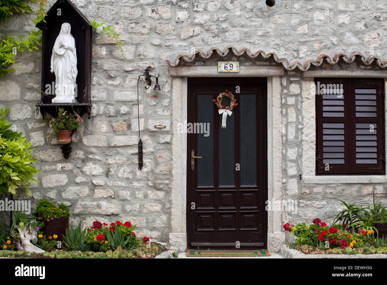 House front door with Holy Mary statue in Osor, island of Cres, Croatia Stock Photo
