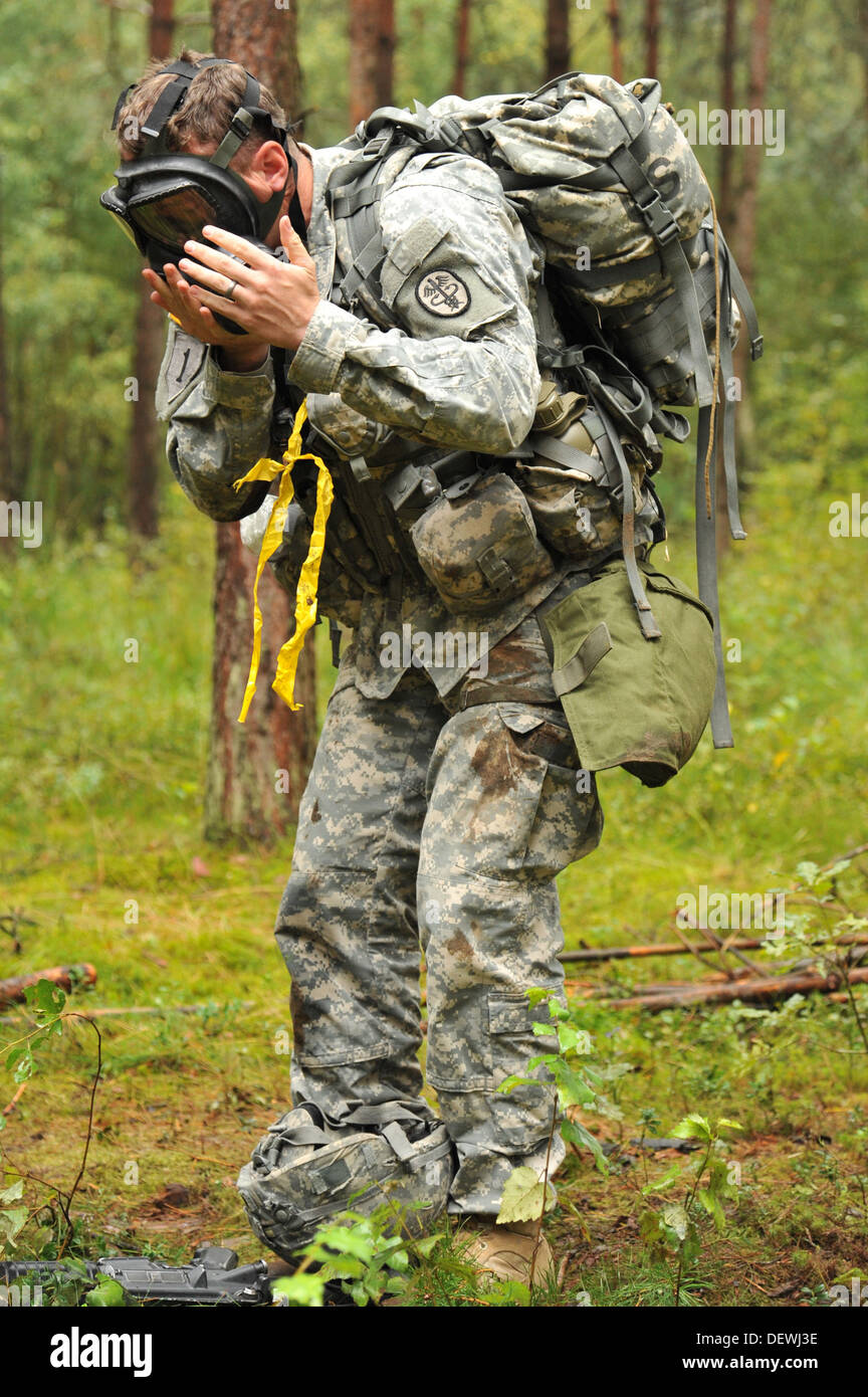U.S. Army Spc. Joshua Virgil dons his protective mask at a combat testing lane during the U.S. Army Europe Expert Field Medical Stock Photo