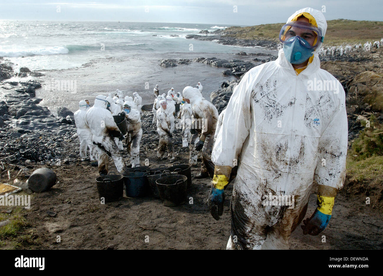 Soldiers dressed with protective clothing cleaning up the oil spill