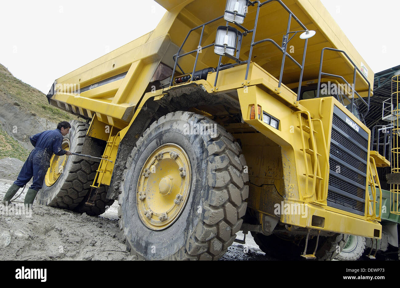 Worker cleaning dumpertruck to carry marl from quarry to cement plant