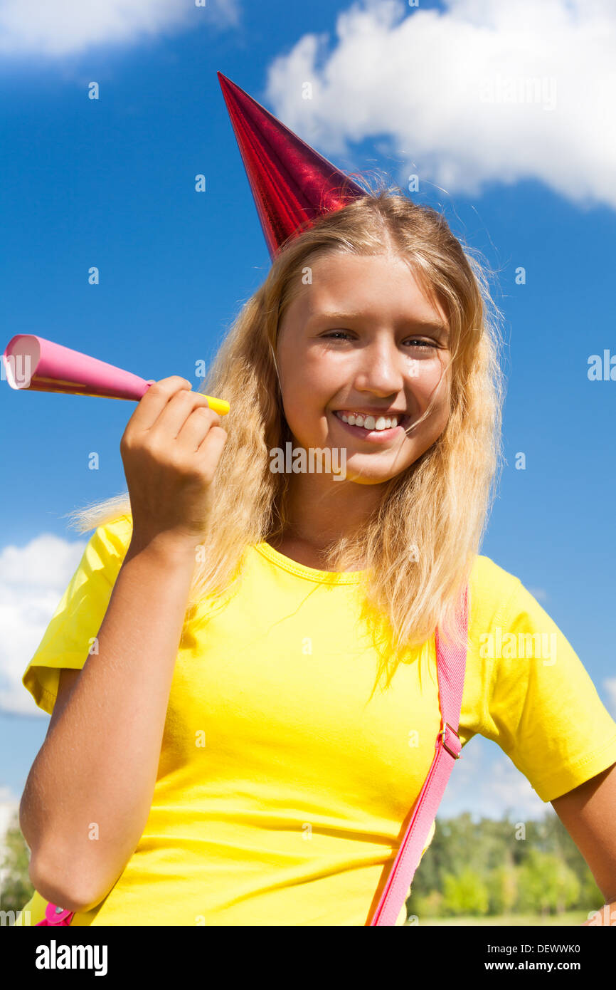 Beautiful little girl with noisemaker horn and birthday party cap
