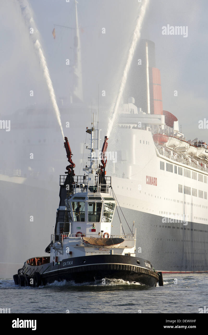 Tugboat and cruise liner Queen Elizabeth 2. Port of Bilbao, Biscay, Basque Country, Spain Stock Photo