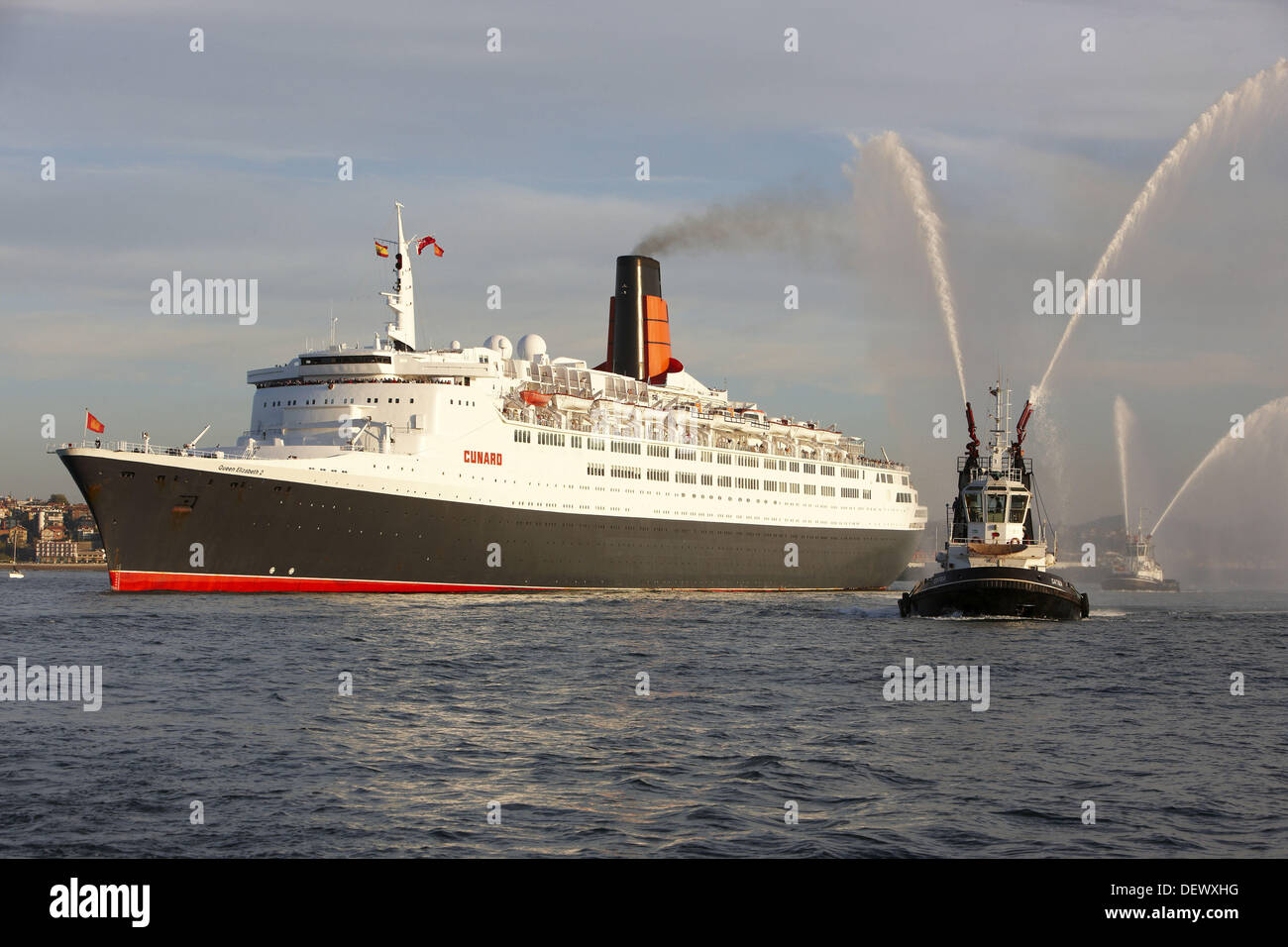 Tugboat and cruise liner Queen Elizabeth 2. Port of Bilbao, Biscay, Basque Country, Spain Stock Photo