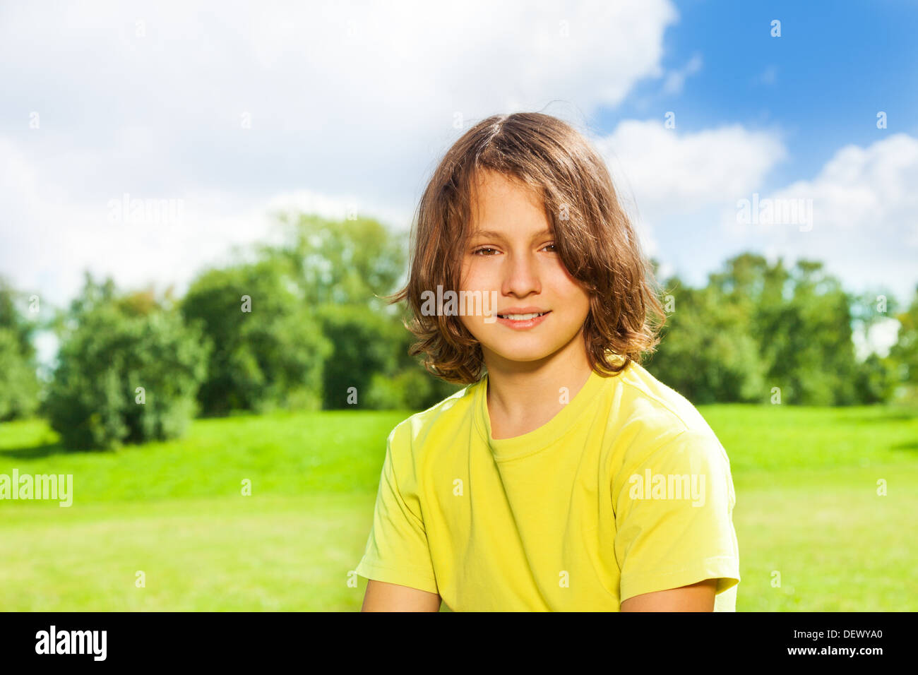 Nice handsome 12 years old boy portrait in the park outside on sunny day Stock Photo