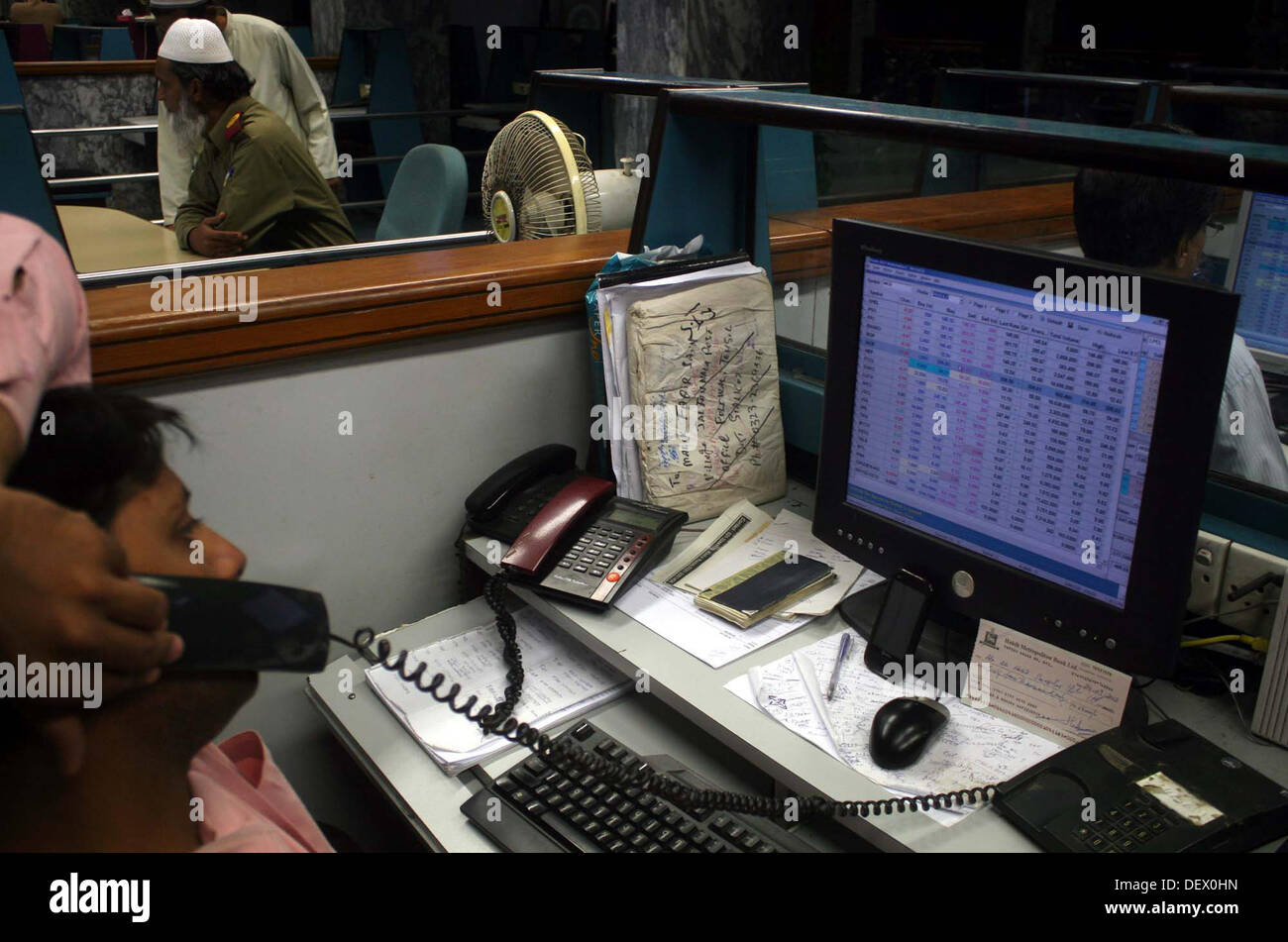 Pakistani traders monitor shares prices at the Karachi Stock Exchange