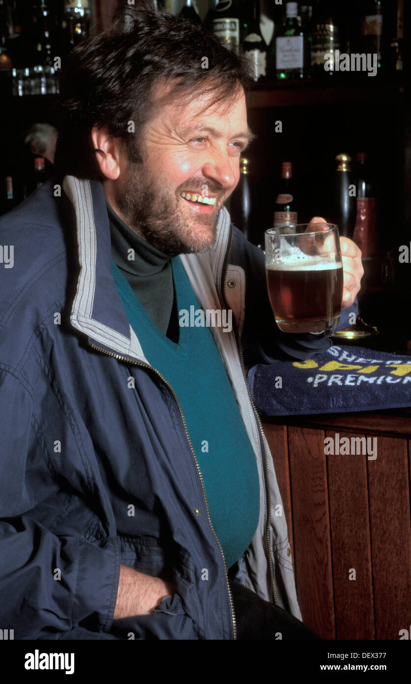 middle aged man with paunch drinking beer in pub Stock Photo