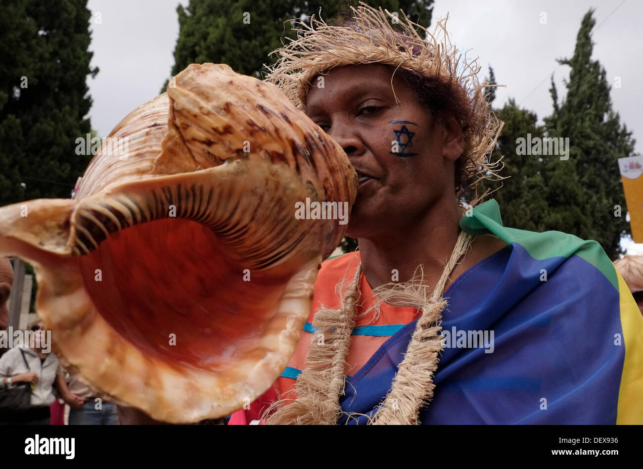 An Evangelical Christian from the Pacific islands blows a huge seashell  during the annual Jerusalem's Sukkot Parade in Israel. Thousands throng to Jerusalem to participate in the annual Sukkot march with participants from cities and towns all over Israel including evangelical Christians and Israel supporters from abroad. Stock Photo