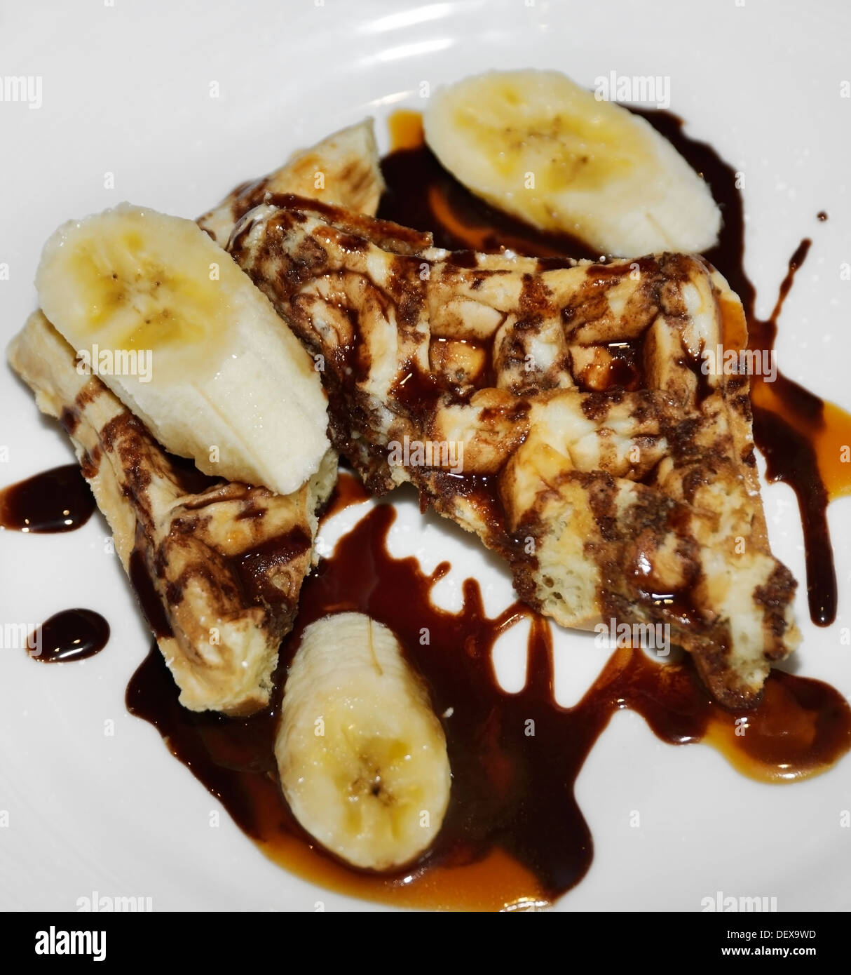 Waffles With Bananas And Chocolate Syrup For Breakfast Stock Photo