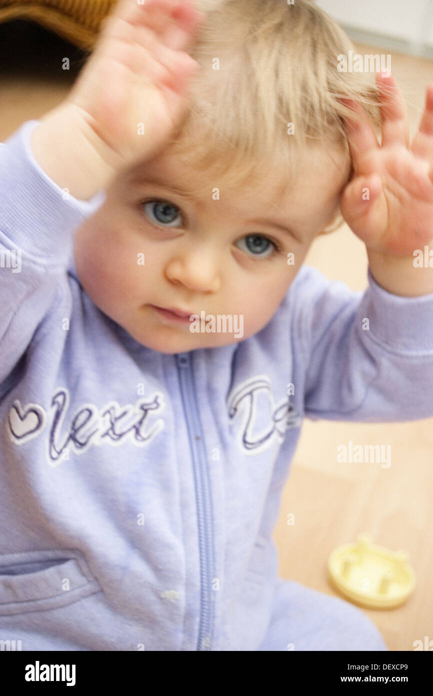 10 month old baby arms in the air, big blue eyes Stock Photo