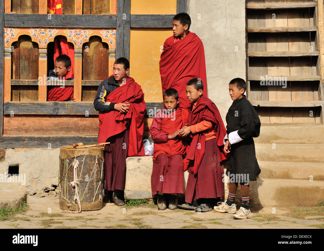 Young monks watching dancers at Domkhar Tsechu festival held in a monastery in the village of Domkhar, Bumthang, Bhutan Stock Photo