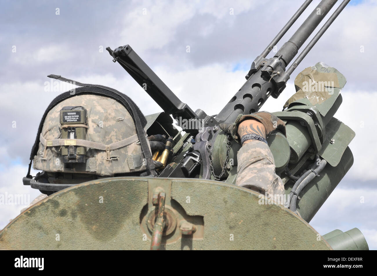 A U.S. Soldier with the 5th Battalion, 20th Infantry Regiment, 3rd Stryker Brigade Combat Team, 2nd Infantry Division, loads his .50-caliber machine gun during a joint platoon exercise at the Yakima Training Center, Wash., Sept. 16, 2013. Rising Thunder i Stock Photo