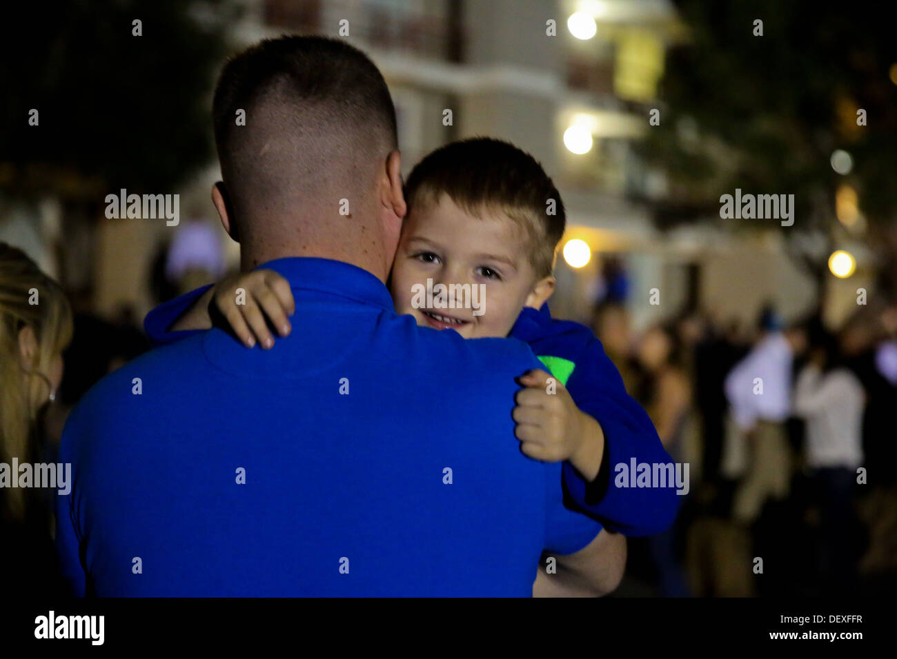 Navy Petty Officer 1st Class Adam Shults, independent duty corpsman, Bravo Company, 1st Battalion, 1st Marine Regiment, and a native of Mt. Sterling, Ky., hugs his son, Lucas, 3, before leaving for a deployment at the parade deck at Camp Horno here, Sept. Stock Photo