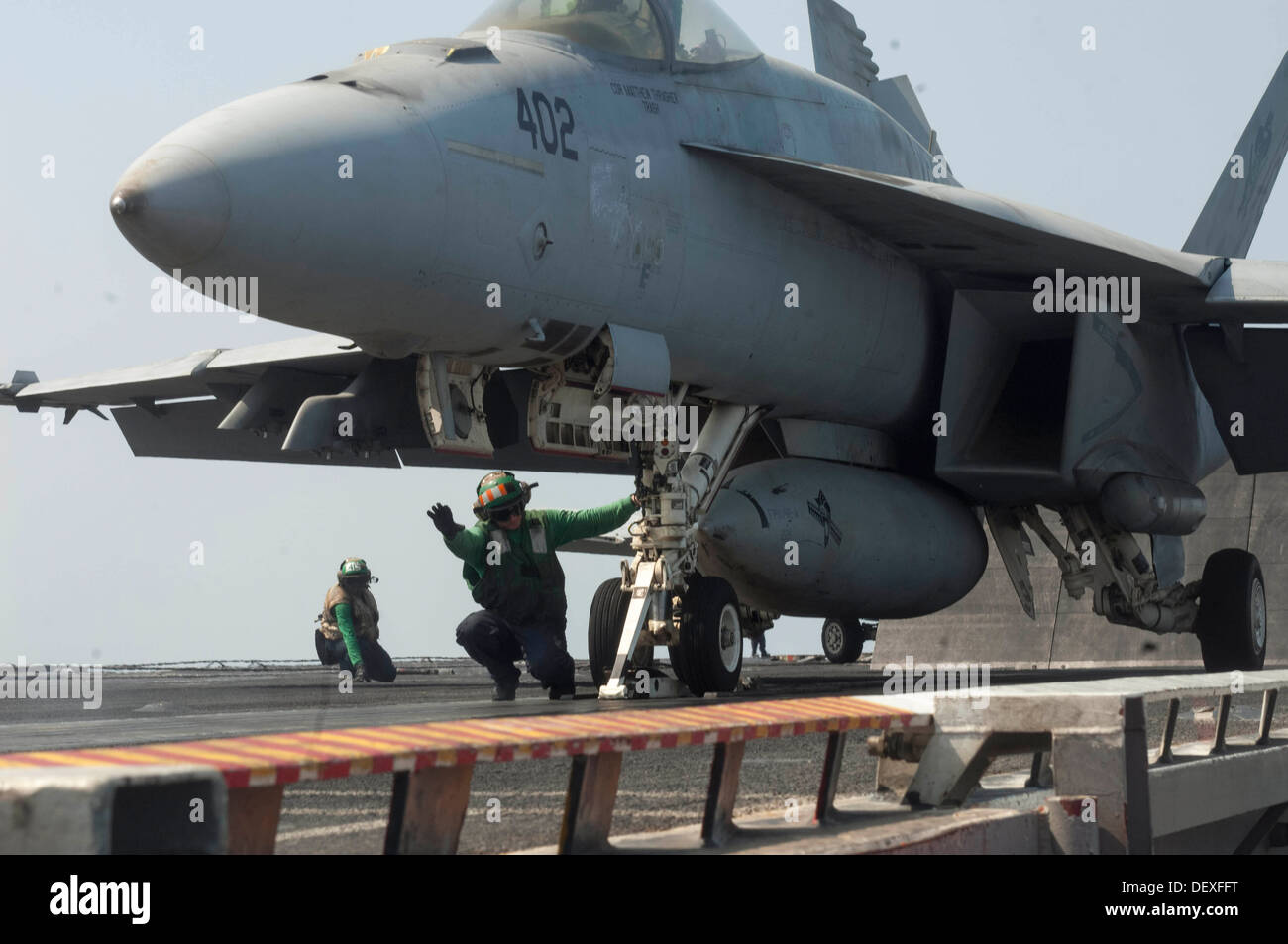 Aviation Boatswain's Mate (Equipment) 3rd Class Echeverria signals that an F/A18E Super