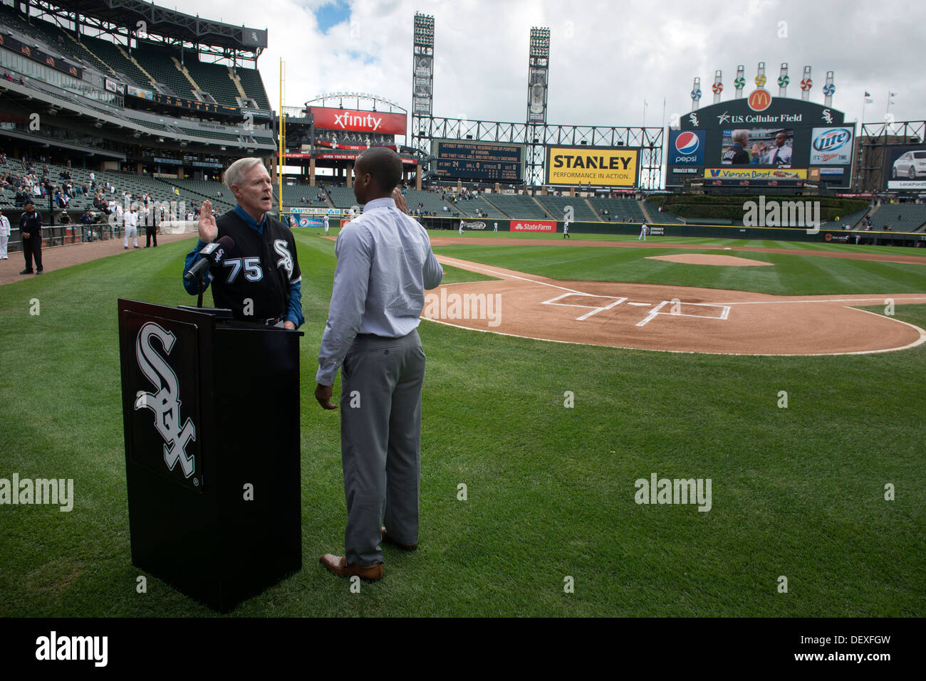 Secretary of the Navy (SECNAV) Ray Mabus administers the oath of office to Ensign Jordan Robinson before a Chicago White Sox Major League Baseball game at Cellular Field. While in Chicago, Mabus took part in a Navy-sponsored Science, Technology, Engineeri Stock Photo