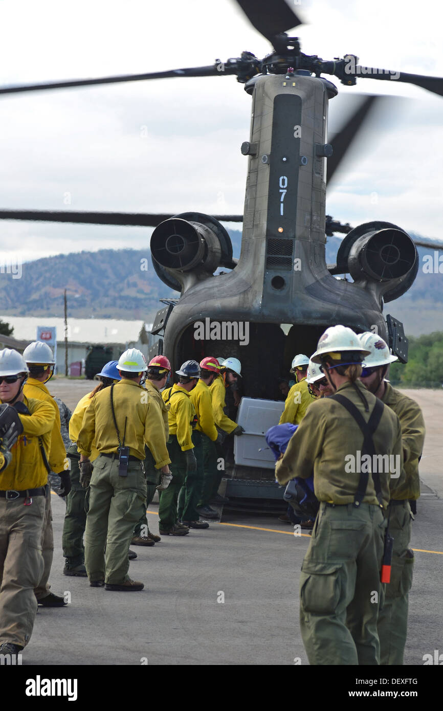 Civilians with the National Forest Service and Bureau of Land Management, help unload animals and evacuees off a U.S. Army Chinook helicopter assigned to the 2nd General Support Aviation Battalion, 4th Aviation Regiment, 4th Combat Aviation Brigade, 4th I Stock Photo