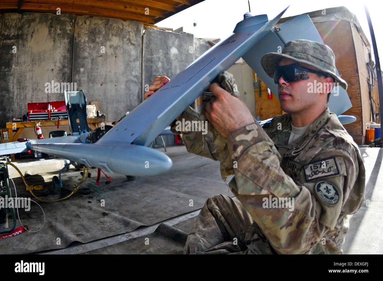 Specialist Nicolas Redondo with Headquarters and Headquarters Troop, Combined Task Force Dragoon, wipes down an RQ7B Shadow Technical Unmanned Aircraft System during post-flight checks Sept. 12, 2013, at Forward Operating Base Pasab, Afghanistan. The Troo Stock Photo