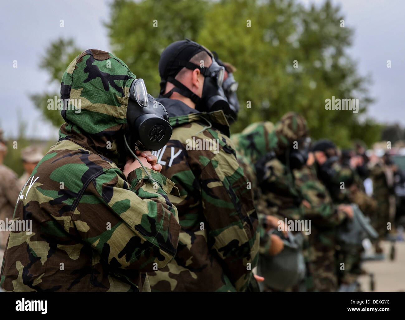 Marines with the 15th Marine Expeditionary Unit put on mission-oriented protective posture level four protective gear during their unit’s chemical, biological, radiological and nuclear defense mask confidence training at Camp Margarita aboard Camp Pendlet Stock Photo