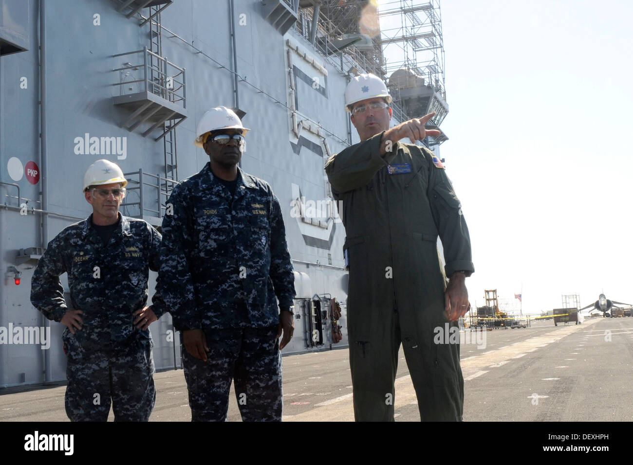 Cmdr. Matthew Niedzwiecki, ship's air boss, discusses maintenance being conducted on the flight deck with Commander, Expeditionary Strike Group 3 Rear Adm. Frank L. Ponds during his visit to amphibious assault ship USS Peleliu (LHA 5). Peleliu is currentl Stock Photo