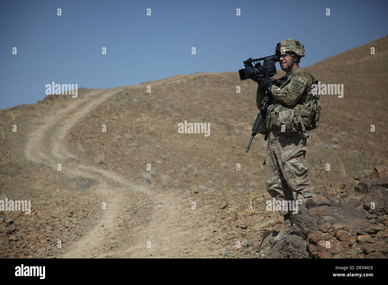 U.S. Army Sgt. Bob Yarborough, a broadcast journalist with the 4th Infantry Brigade Combat Team, 3rd Infantry Division, documents a live-fire exercise in Logar Province, Afghanistan, Sept. 18, 2013. Stock Photo