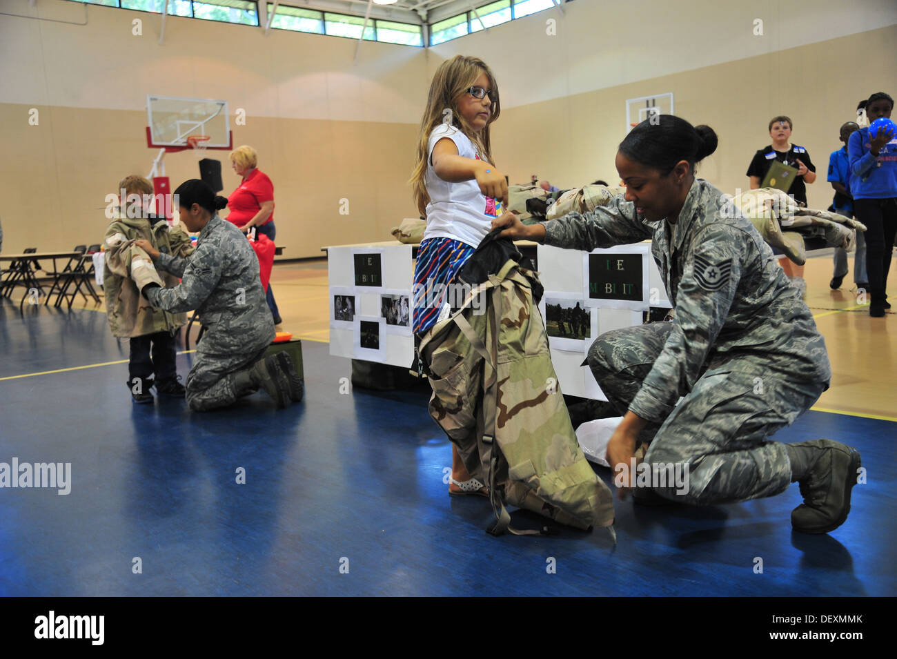 U.S. Air Force airmen assigned to the 4th Logistics Readiness Squadron help children don mission oriented protective posture gear during Operation Bug Out, a mock deployment for children, at Seymour Johnson Air Force Base, N.C., Sept. 19, 2013. The childr Stock Photo