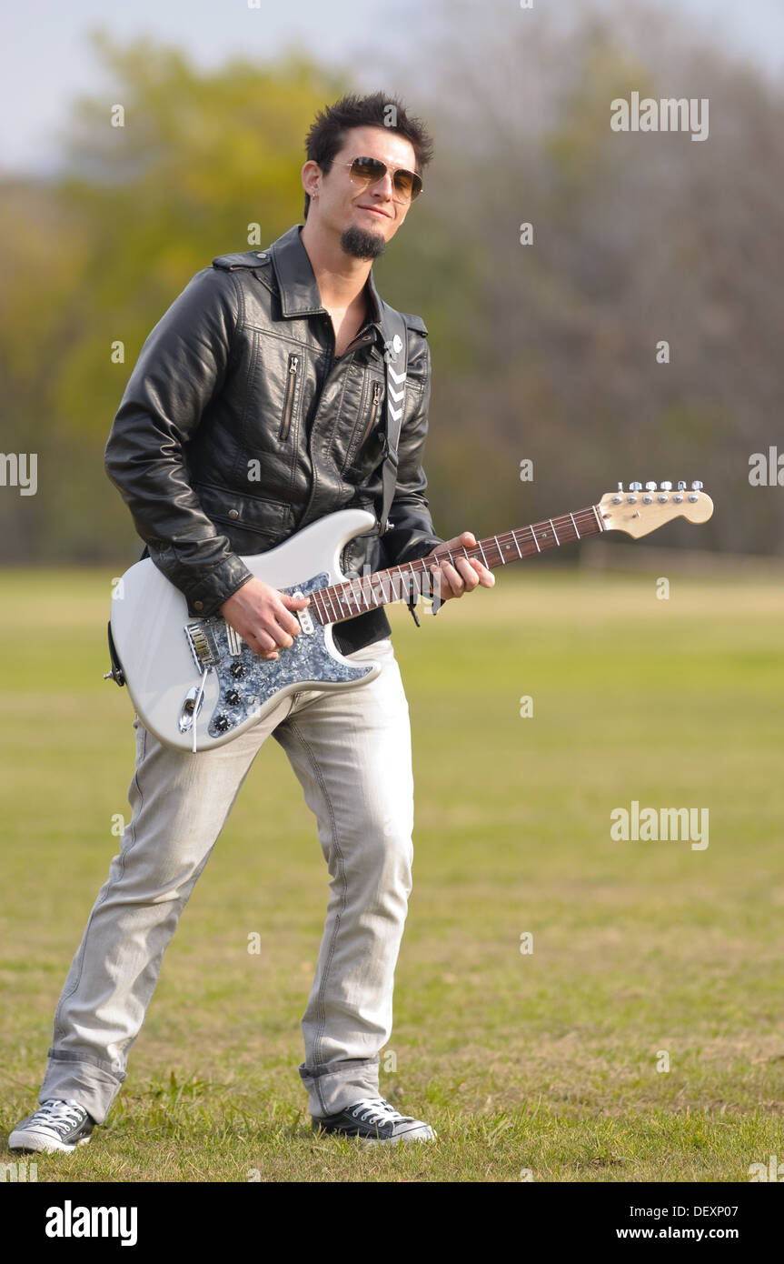 young rock musician playing electric guitar outdoor Stock Photo
