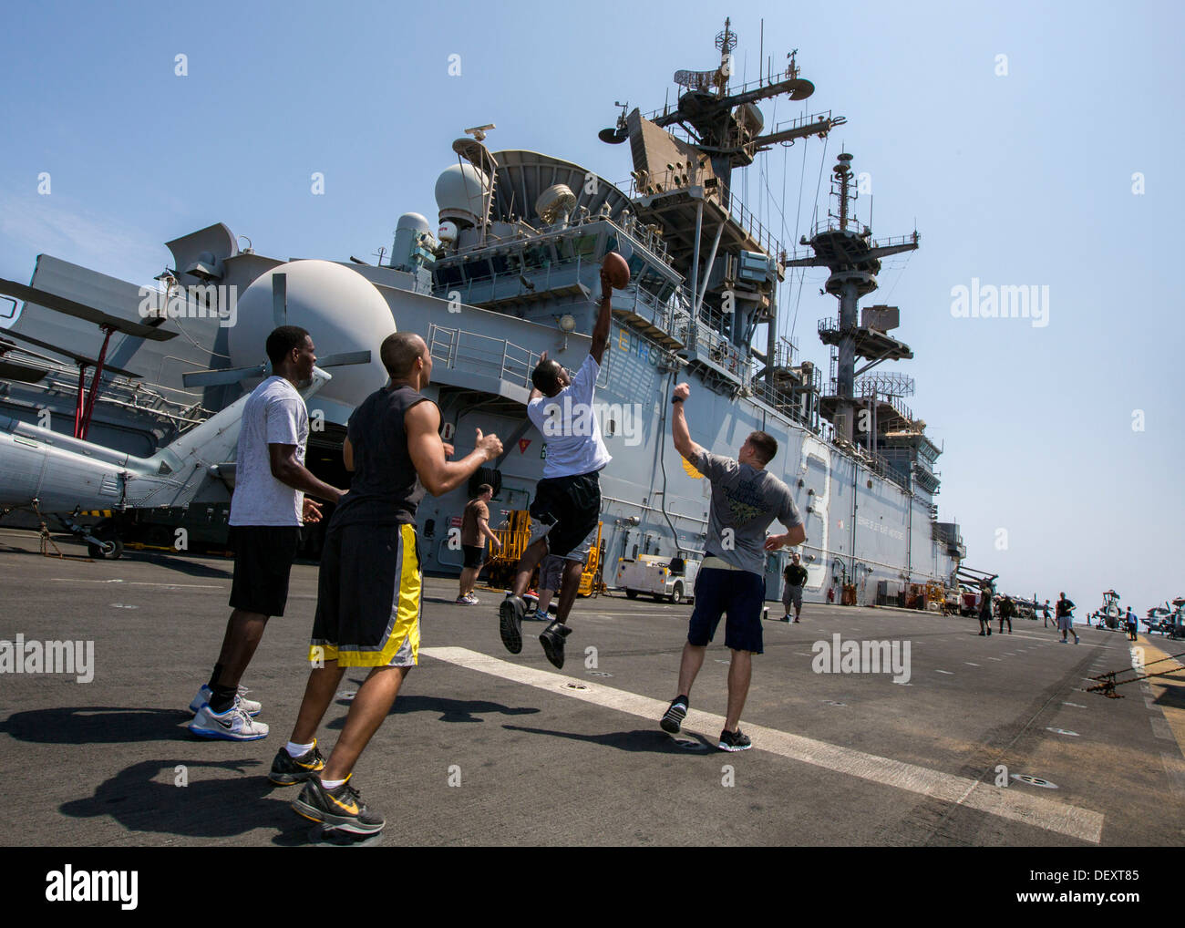 U.S. Marines and sailors assigned to 26th Marine Expeditionary Unit (MEU), play football on the flight deck of the USS Kearsarge (LHD 3) during a steel beach Morale Welfare and Recreation event, Sept. 20, 2013.The 26th MEU is a Marine Air-Ground Task Forc Stock Photo