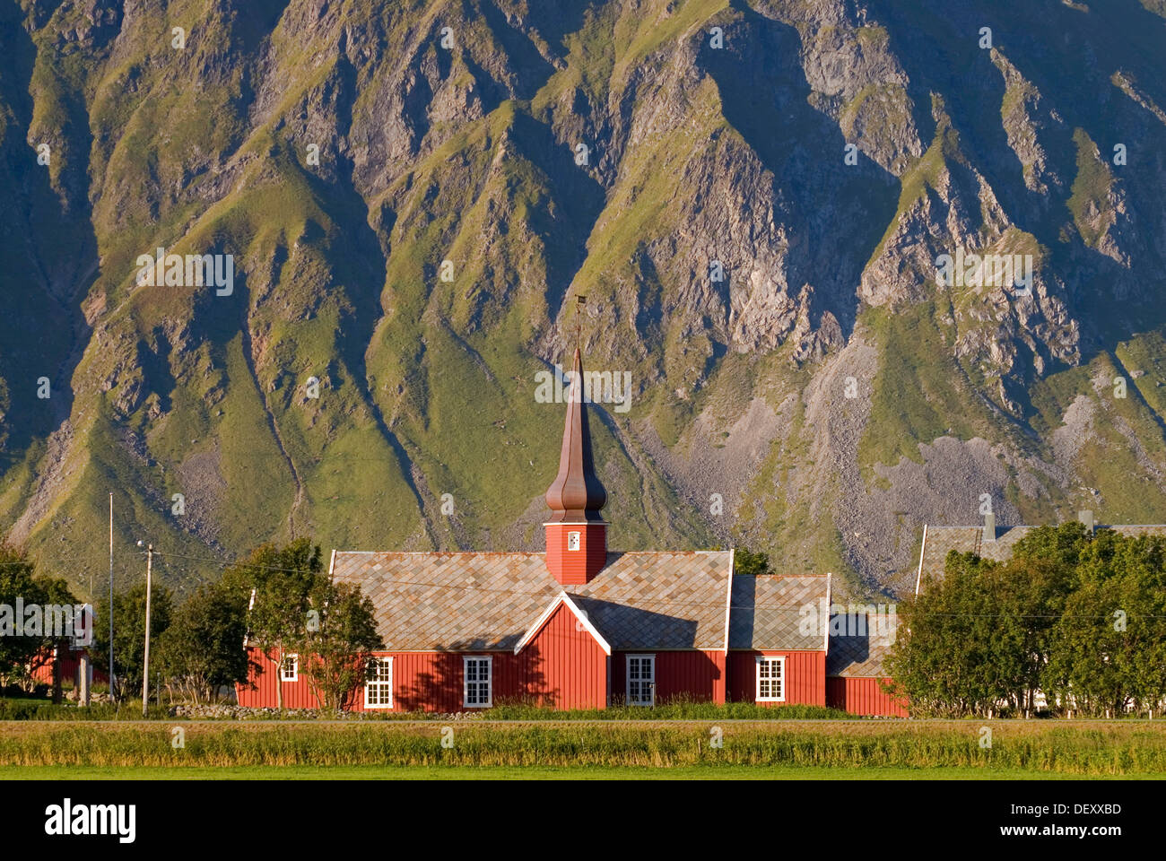 The red stave church of Flakstad in front of steep mountains, Vareid