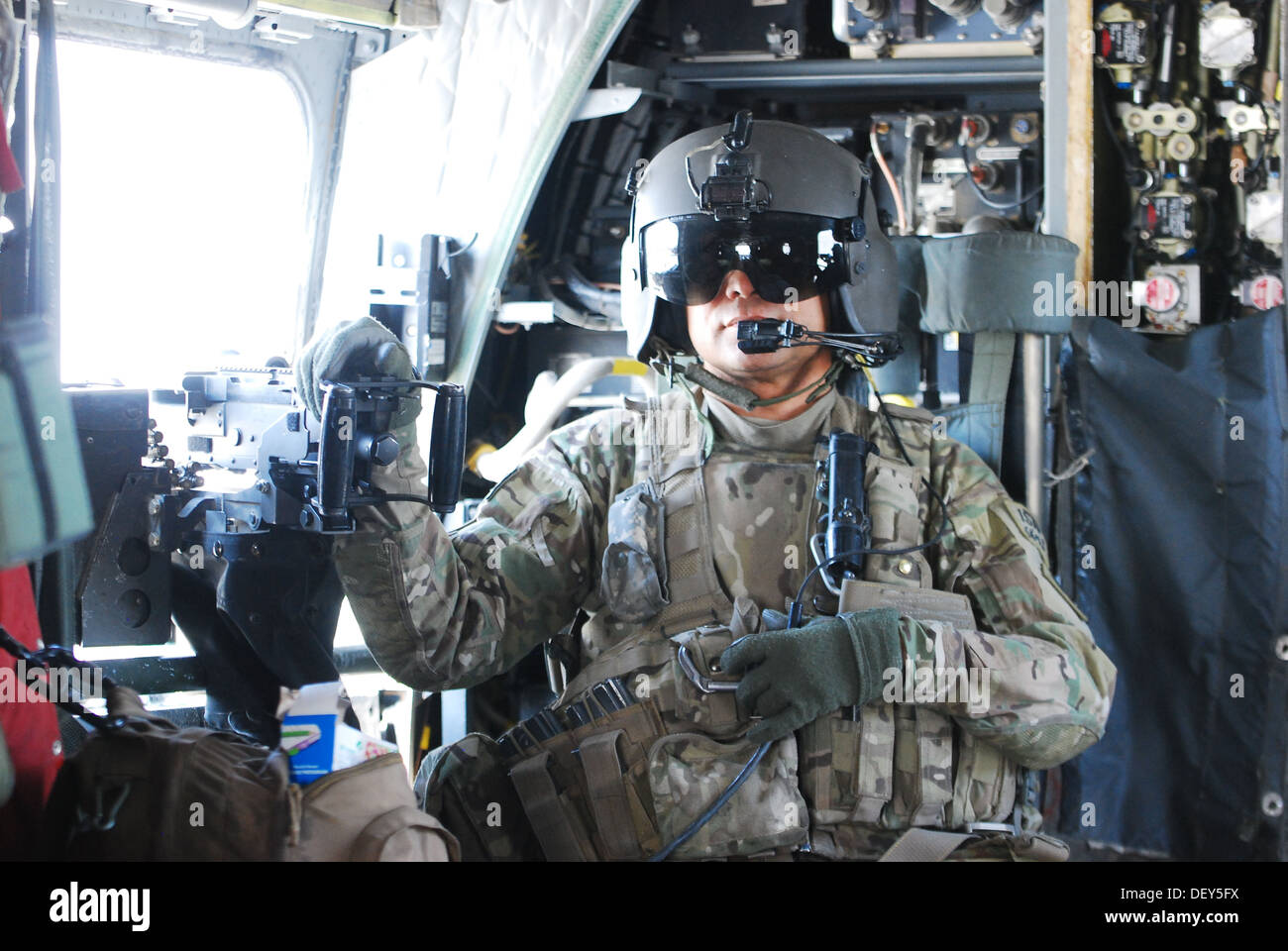 Staff Sgt. Ignacio Lopez, a CH-47 Chinook helicopter flight engineer assigned to B Company, 2nd Battalion (General Support), 149th Aviation Regiment (Texas/Oklahoma National Guard), serving under the 10th Combat Aviation Brigade, communicates with the air Stock Photo