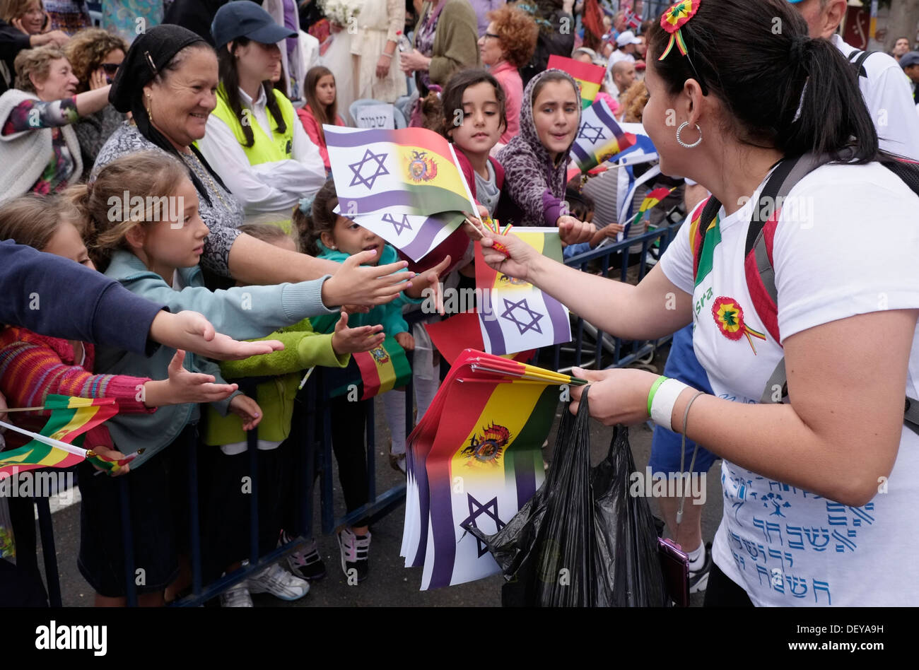 An Evangelical Christian from Bolivia distributing the Bolivian and Israeli flags to Israeli onlookers as she takes part in the annual Jerusalem's Sukkot Parade Israel. Thousands of Christians from around the world travel to Israel every year during Sukkot or the feast of the Tabernacles holiday to show their love for the Jewish people and the state of Israel. Stock Photo