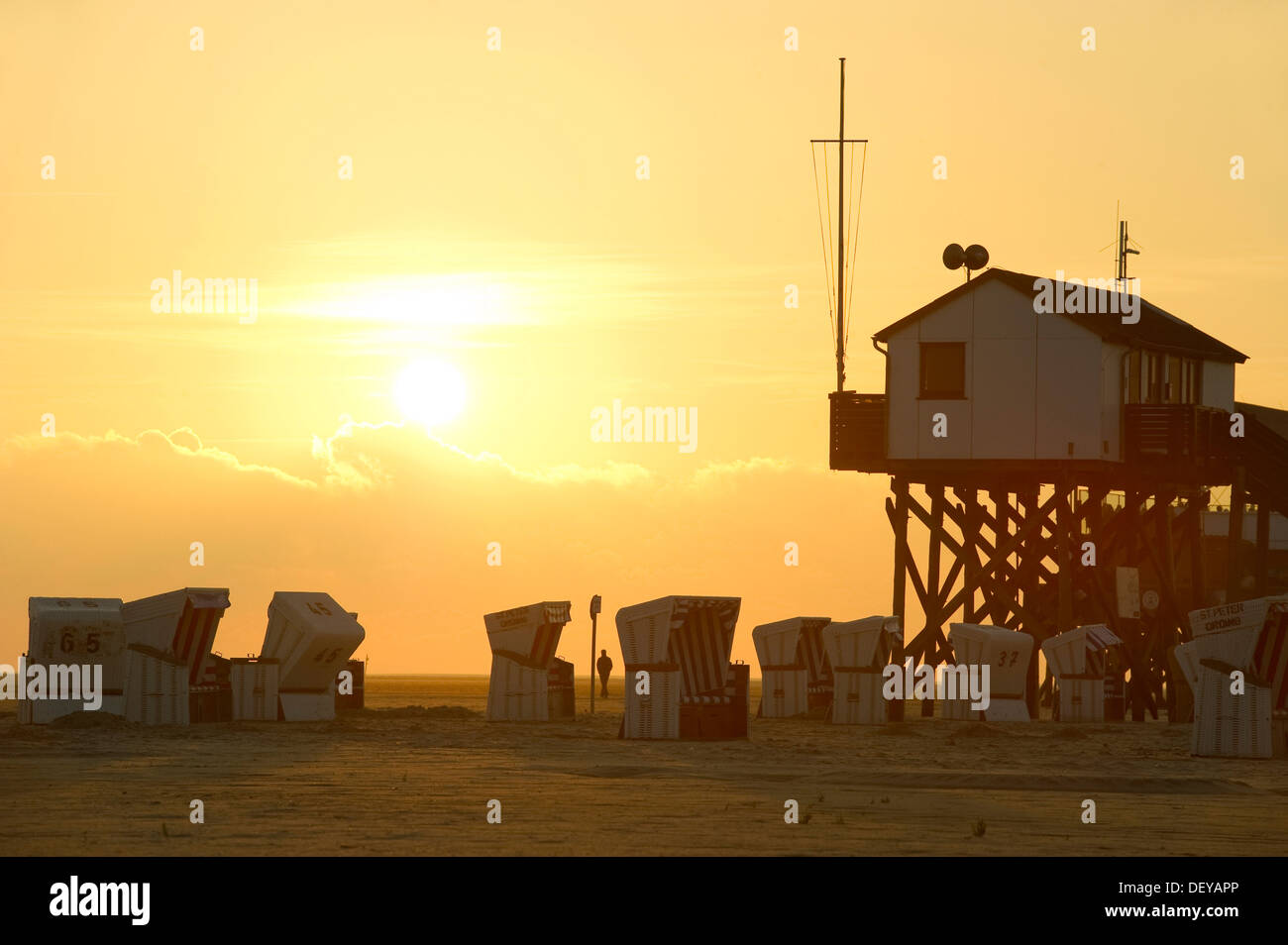 Building on stilts and roofed wicker beach chairs on the beach of St