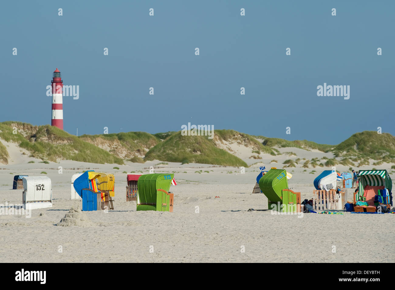 Roofed wicker beach chairs and lighthouse at Nebel, Amrum, North Frisian Islands, Schleswig-Holstein Stock Photo