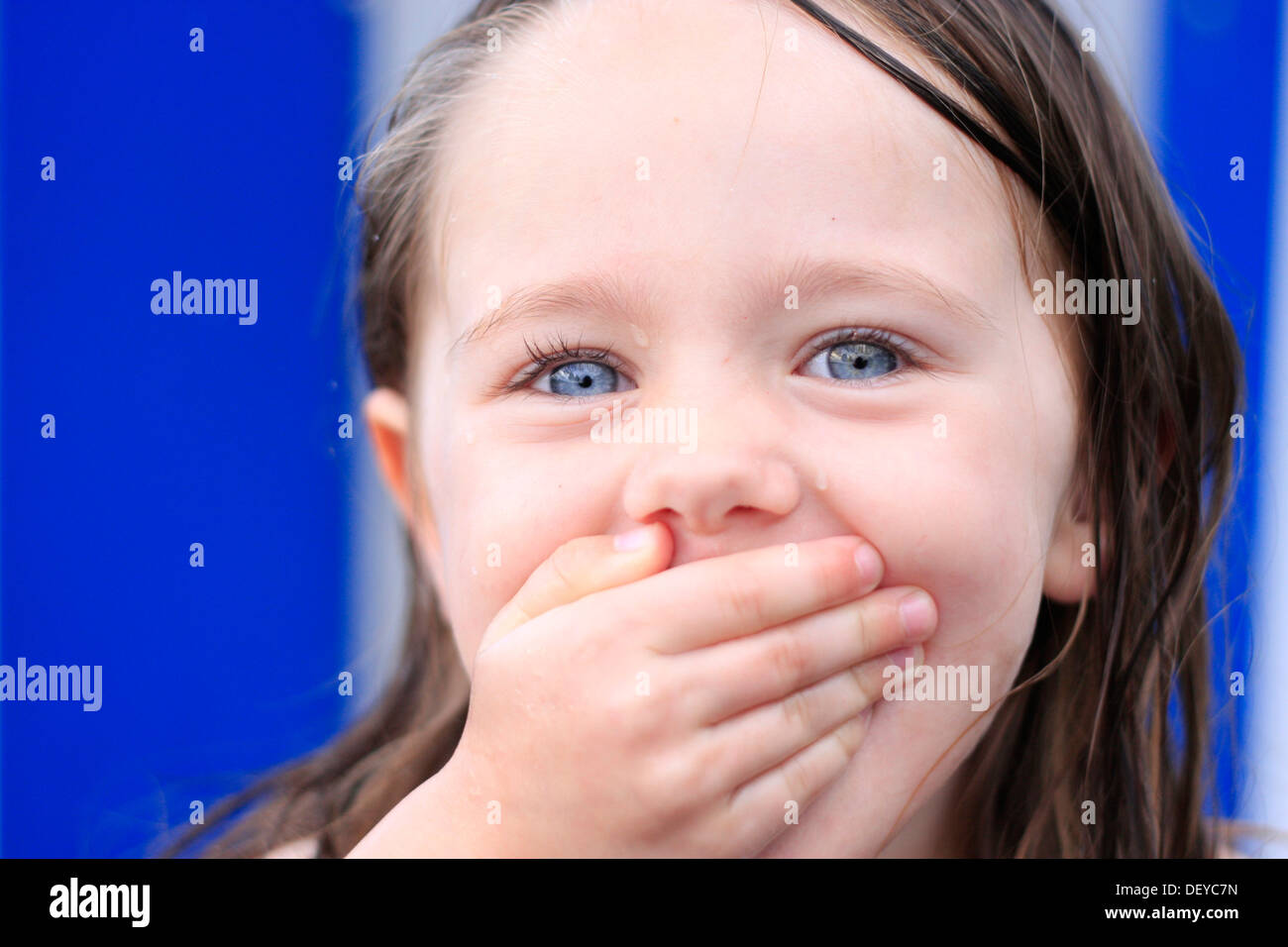 Little girl, three years, holding her mouth laughing Stock Photo