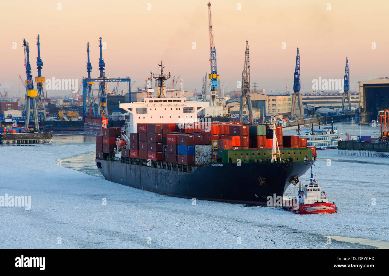 Container ship on the Elbe river in the wintery port of Hamburg Stock Photo
