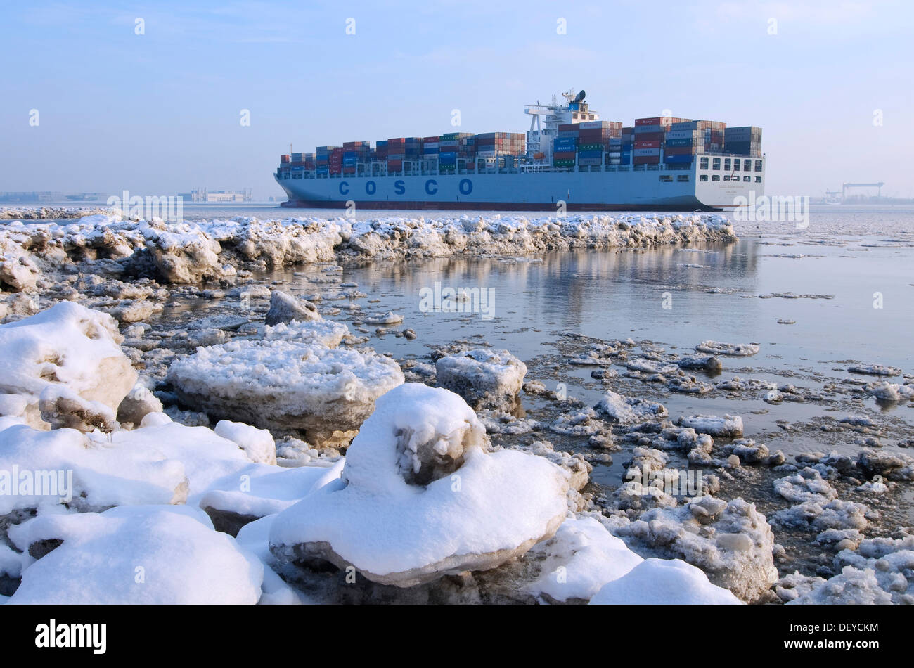 A container ship travelling on the wintery Elbe river at Blankenese, Hamburg Stock Photo