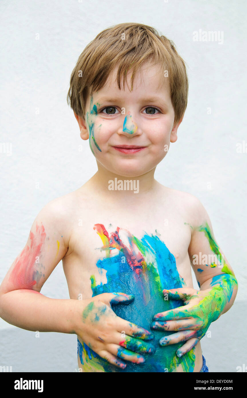 Little boy, three years, has painted on himself with finger paint Stock Photo