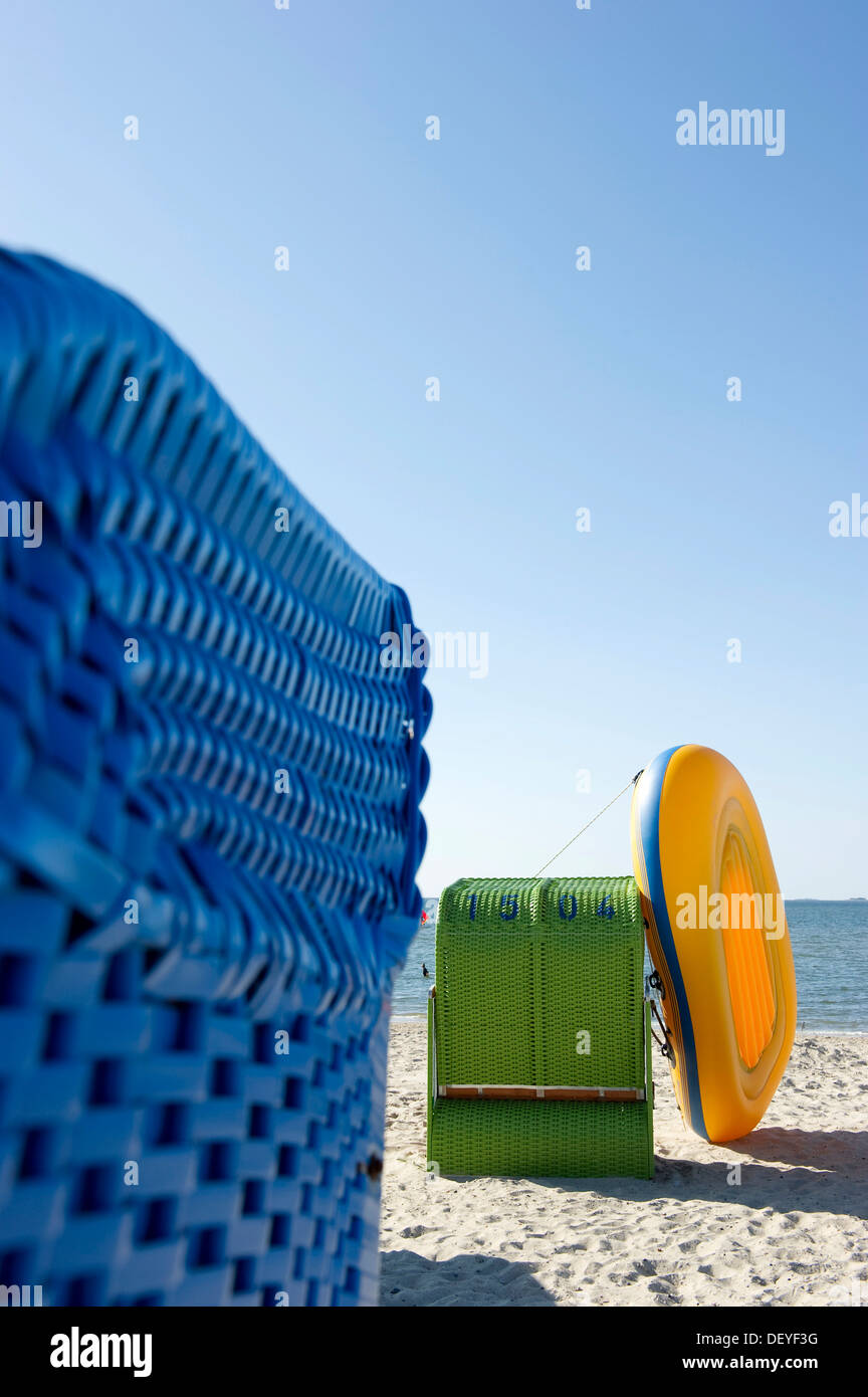 Colourful roofed wicker beach chairs and a yellow inflatable boat, Amrum, North Frisian Islands, Schleswig-Holstein, Germany Stock Photo