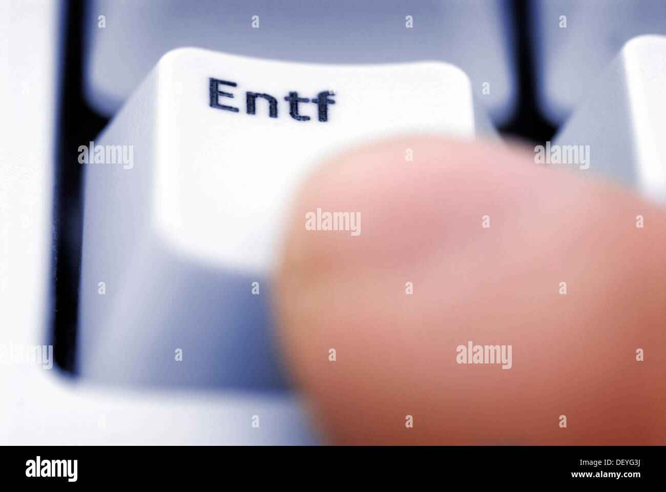 Finger pressing the delete key on a computer keyboard, symbolic image for the deletion of stored