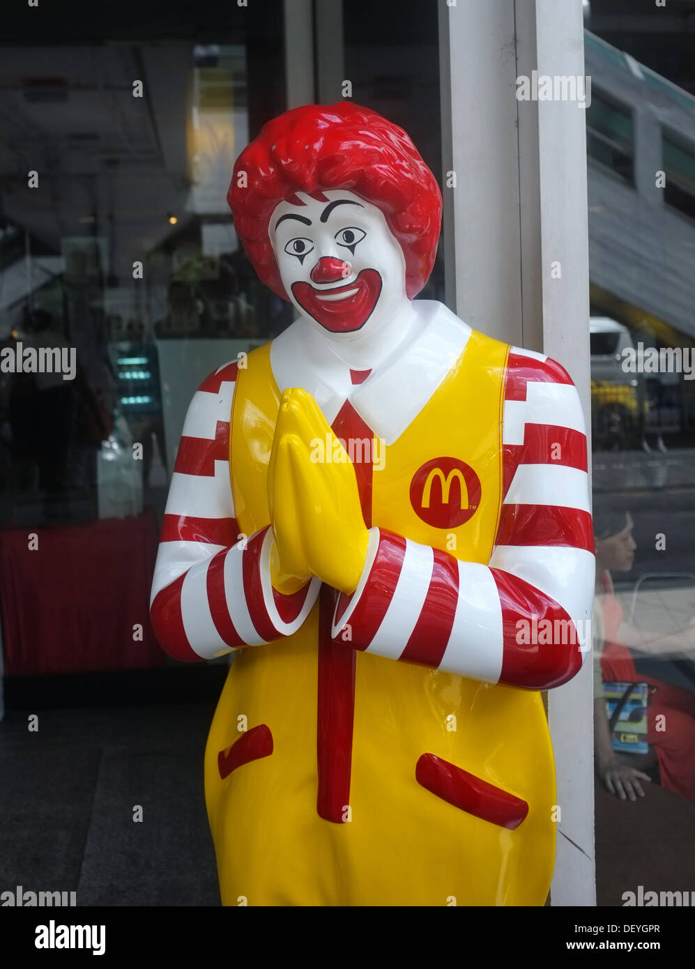 Ronald McDonald statue makes a 'wai' gesure outside a McDonald's in Bangkok, Thailand Stock Photo