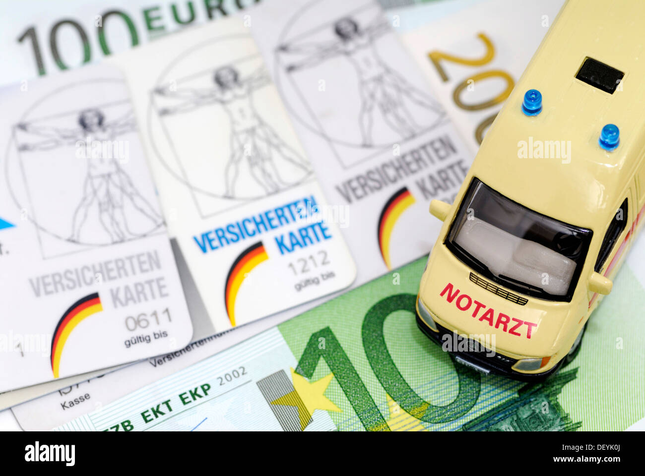 Health insurance cards and miniature ambulance, symbolic image for