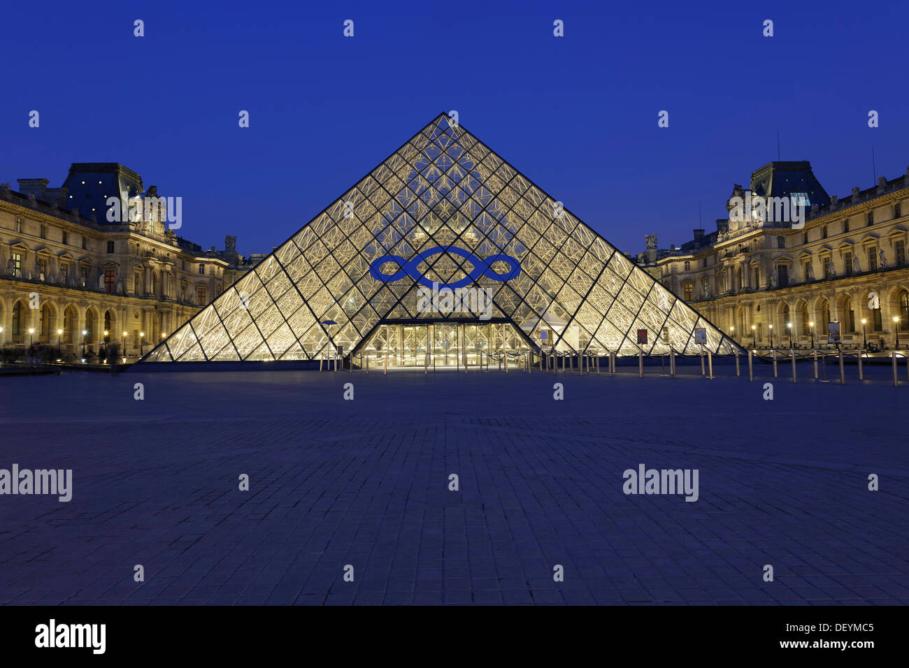 Entrance pyramid by architect I.M. Pei, Musée du Louvre, Louvre Museum, with a logo advertising an exhibition by Michelangelo Stock Photo
